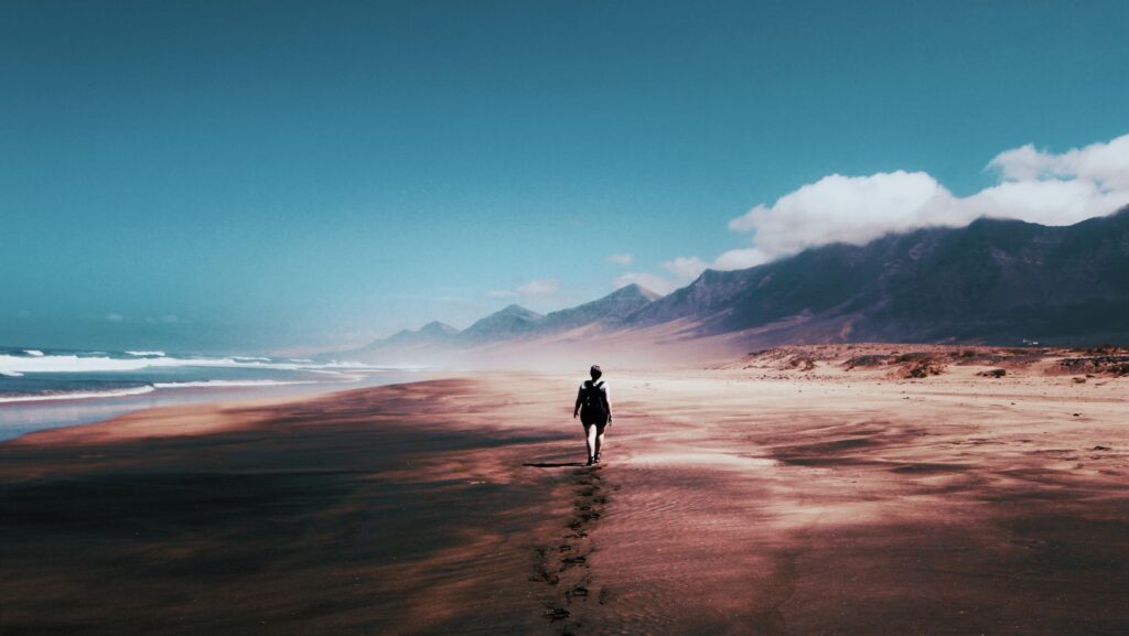 femeie mergâng pe plajă la mare