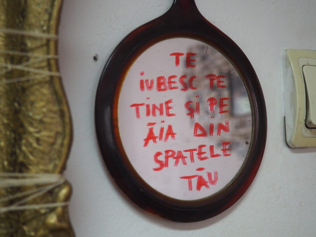 Oglindă cu scris „te iubesc pe tine și pe ăia din spatele tău”